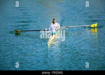 Zwei Mann in einem Boot rudern auf dem ruhigen See Stockfoto