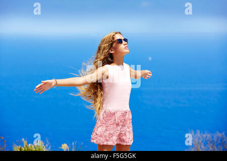 Blonde Mädchen schütteln Haare auf Luft im blauen Mittelmeer-Tourist in Spanien öffnen Hände Stockfoto