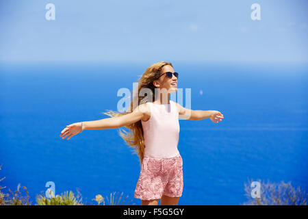 Blonde Mädchen schütteln Haare auf Luft im blauen Mittelmeer-Tourist in Spanien öffnen Hände Stockfoto