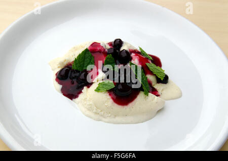 Gutes Dessert mit Vanille-Eis und Aronia Marmelade mit Zitronenmelisse auf Topp, Bild aus Nordschweden. Stockfoto