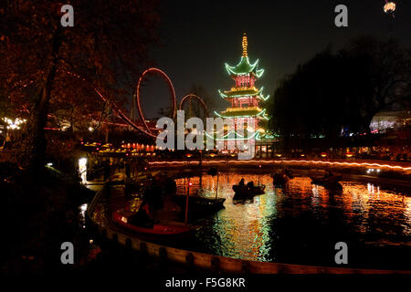 Die Drachenboote im See vor dem japanischen Turmrestaurant und Fahrten in der Nacht in Tivoli Gärten auf einem dunklen Halloween Stockfoto