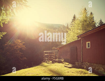 Retro Vintage stilisierte Berghütte gegen Sonne mit Flare-Effekt. Stockfoto