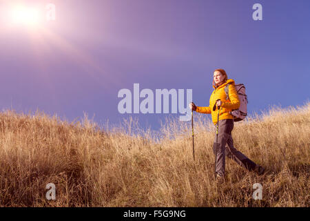 Weibliche Wanderer zu Fuß auf grasbewachsenen Hügel Stockfoto