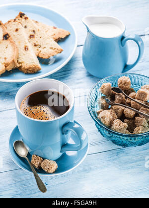 Tasse Kaffee, Milchkännchen, Rohrzucker Würfel und Obstkuchen auf alten Holztisch. Stockfoto