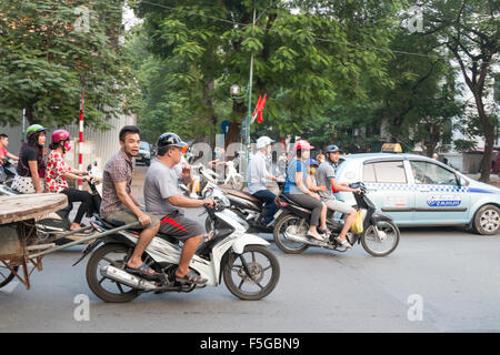 Hanoi Hauptstadt Vietnams. Der Verkehr, der sich durch das Stadtzentrum zieht, Menschen, die mit Motorrollern und Mopeds fahren Stockfoto