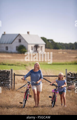 Schweden, Gotland, Faro, Mutter und Tochter auf dem Bauernhof wheeling Fahrräder (10-11)