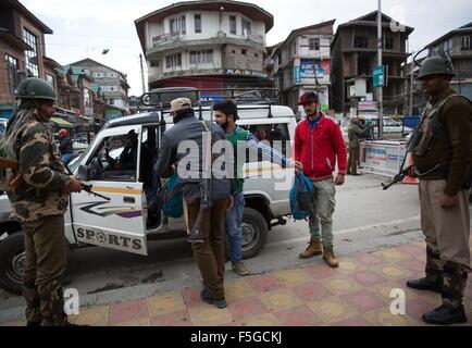 Srinagar, Kaschmir Indien kontrollierten. 4. November 2015. Ein indische Polizisten frisks einen Passagier, wie indische paramilitärische Soldaten Wache an einem temporären Checkpoint in Srinagar, Sommer in der Hauptstadt von Indien kontrollierten Kaschmir, 4. November 2015 stehen. Behörden in Indien kontrollierten Kaschmir verstärkt Sicherheit vor der indische Premierminister Narendra Modi geplanten Besuch am Samstag. © Javed Dar/Xinhua/Alamy Live-Nachrichten Stockfoto