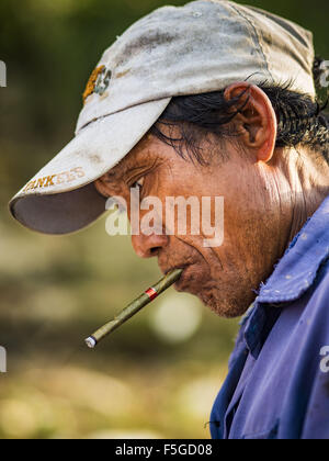 4. November 2015 - Dala, Yangon Division, Myanmar - Reparatur ein Arbeitnehmers mit einem Cheroot geballt in den Mund den Rumpf des kleinen Holzfähre an den Ufern des Flusses Yangon in Dala. Dala befindet sich am südlichen Ufer von Yangon River gegenüber dem Zentrum von Yangon, Myanmar. Viele Burmesen Leben in Dala und umliegenden Gemeinden und in zentralen Yangon für Arbeit über den Fluss gehen. Vor dem 2. Weltkrieg hatte der Irrawaddy Flotilla Company seine wichtigsten Werften in Dala. Dass Tradition in die kleine Reparatur-Unternehmen die Arbeit auf die Hunderte von kleinen Holzbooten, die lebt als Pendler für Fähren dienen der Stockfoto