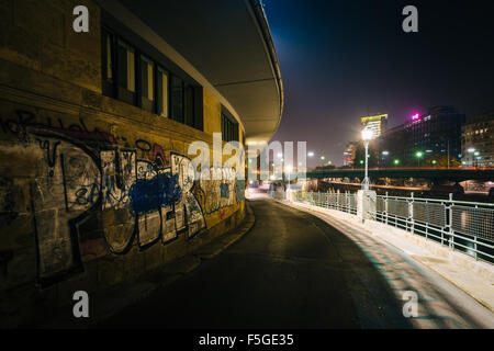 Graffiti an der Wand über den Donaukanal in der Nacht, in Wien, Österreich. Stockfoto