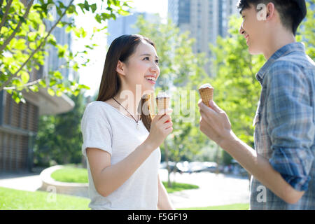 Glückliches junges Paar Eis essen Stockfoto