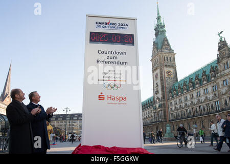 Hamburg, Deutschland. 4. November 2015. Hamburgs Bürgermeister Olaf Scholz (SPD, l) und Haspa Chef Harald Vogelsang offenbaren eine Countdown-Uhr für die Olympischen Spiele in der Rathausmarkt in Hamburg, Deutschland, 4. November 2015. Die Uhr von Mittwoch ab zeigt zunächst die verbleibende Zeit bis zum Ende des Referendums für die Olympia-Bewerbung am 29. November, 18.00 Uhr. In einem Referendum entscheiden die Bürgerinnen und Bürger der Hansestadt Stadt sollte gelten auch für Deutschland zu Olympia 2024. Foto: CHRISTIAN CHARISIUS/Dpa/Alamy Live News Stockfoto