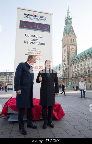 Hamburg, Deutschland. 4. November 2015. Hamburgs Bürgermeister Olaf Scholz (SPD, l) und Haspa Chef Harald Vogelsang offenbaren eine Countdown-Uhr für die Olympischen Spiele in der Rathausmarkt in Hamburg, Deutschland, 4. November 2015. Die Uhr von Mittwoch ab zeigt zunächst die verbleibende Zeit bis zum Ende des Referendums für die Olympia-Bewerbung am 29. November, 18.00 Uhr. In einem Referendum entscheiden die Bürgerinnen und Bürger der Hansestadt Stadt sollte gelten auch für Deutschland zu Olympia 2024. Foto: CHRISTIAN CHARISIUS/Dpa/Alamy Live News Stockfoto