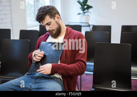 Hübscher Kerl sitzt und Sleaping im Klassenzimmer Stockfoto