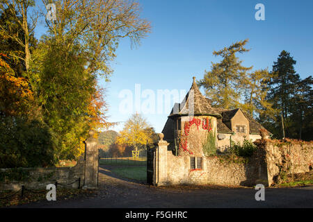 Stowell Park Estate Tor Haus und Buche Bäume mit Herbst Laub in der Cotswold-Landschaft. Gloucestershire, England. Stockfoto