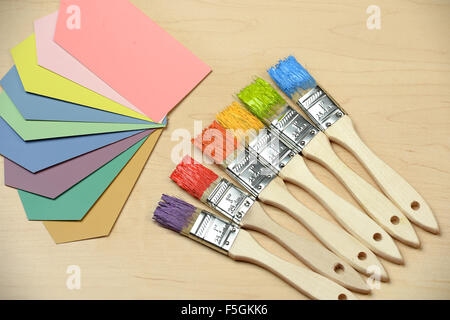Auswahl an Farbmustern und Pinsel auf Holztisch Stockfoto