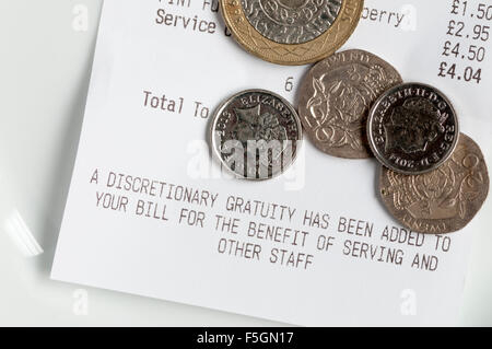 Geld mit Rechnung auf Untertasse im Restaurant oder Café.  Bill sagt, dass eine Ermessen Trinkgeld für die Zustellung von Personal und andere hinzugefügt wurde Stockfoto