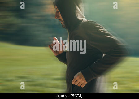 Vermummte Mann Joggen im Park im frühen Herbstmorgen, Sport, Erholung und gesunden Lifestyle-Konzept, Retro-getönten Bild Stockfoto
