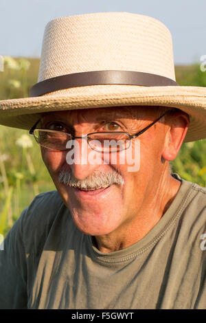Älterer Mann mit Sonnencreme weißen Schnurrbart und Stroh Hut Stockfoto