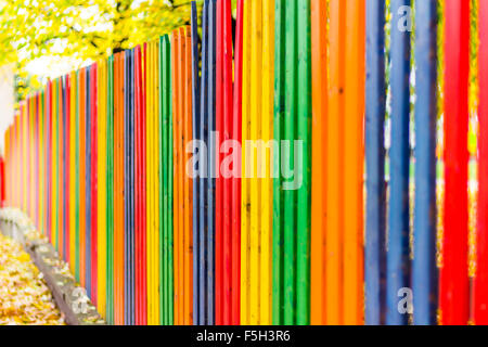 Multi farbige Regenbogen Holzzaun im Herbst, Garten Hintergrund, Weichzeichner, geringe Schärfentiefe Stockfoto