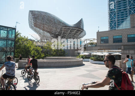 Fisch oder Peix, Gehrys Bronzeskulptur am Olympischen Hafen Zone. Sonne Badegäste am städtischen Strand von Barceloneta, Barcelona, Catalan, Spanien Stockfoto