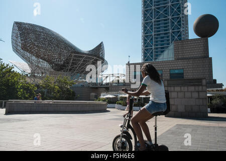 Fisch oder Peix, Gehrys Bronzeskulptur am Olympischen Hafen Zone. Sonne Badegäste am städtischen Strand von Barceloneta, Barcelona, Catalan, Spanien Stockfoto