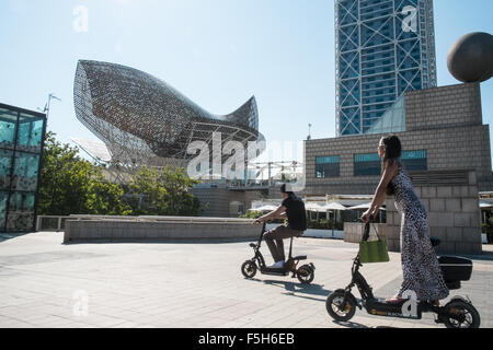 Fisch oder Peix, Gehrys Bronzeskulptur am Olympischen Hafen Zone. Sonne Badegäste am städtischen Strand von Barceloneta, Barcelona, Catalan, Spanien Stockfoto