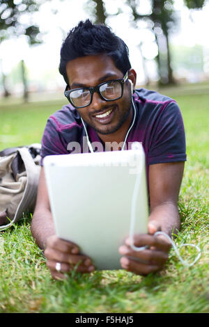 Student in den Park mit seinem Tablettcomputer Stockfoto