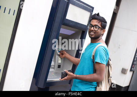 indischen Jüngling am Cashpoint Withdrwing Geld Stockfoto