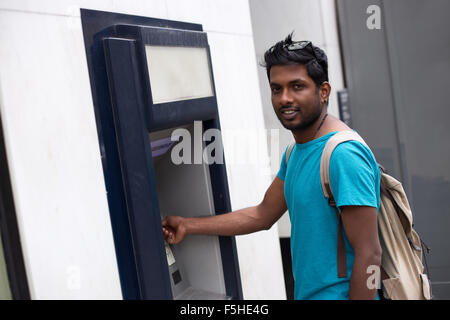 junger Mann an der Cash-Maschine Stockfoto