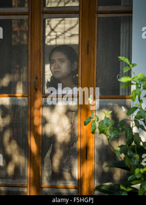 Yangon, Myanmar. 5. November 2015. Eine Frau blickt aus der Haustür zu Hause von Aung San Suu Kyi. Sie lebte im Haus Verhaftung hier seit mehr als 15 Jahren. Suu Kyi jetzt bestreitet einen nationalen Wahlen in Myanmar und Gastgeber einer Pressekonferenz bei ihr zu Hause. Während der Pressekonferenz, die 90 Minuten dauerte, sagte Aung San Suu Kyi, der Führer der Nationalliga für Demokratie (NLD), dass wenn die NLD die Wahlen gewann sie '' über '' der Präsident dienen würde. Bildnachweis: ZUMA Press, Inc./Alamy Live-Nachrichten Stockfoto