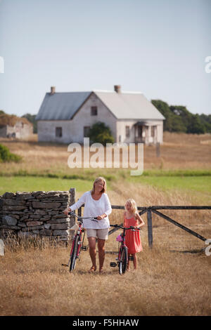 Schweden, Gotland, Faro, Mutter und Tochter auf dem Bauernhof wheeling Fahrräder (8-9)