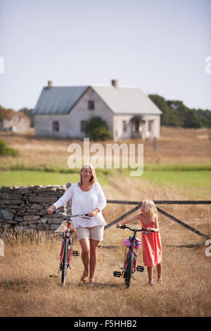 Schweden, Gotland, Faro, Mutter und Tochter auf dem Bauernhof wheeling Fahrräder (8-9)