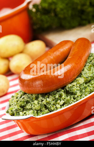 Einem rustikalen Tisch mit ein Gericht mit "trafen sich Boerenkool schlimmsten Fall" oder Grünkohl mit geräucherter Wurst; eine traditionelle holländische Mahlzeit. Stockfoto