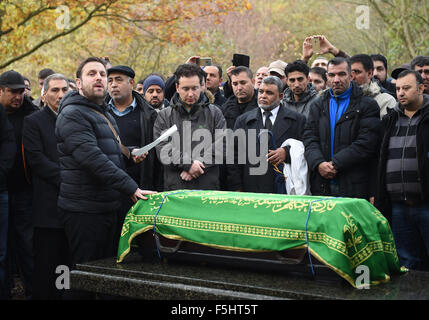 Berlin, Deutschland. 5. November 2015. Trauernden stehen rund um den Sarg bei der Beerdigung des ermordeten Flüchtlingen junge Mohamed in der muslimischen Abschnitt des Friedhofs in Gatow in Berlin, Deutschland, 5. November 2015. Foto: BRITTA PEDERSEN/Dpa/Alamy Live News Stockfoto