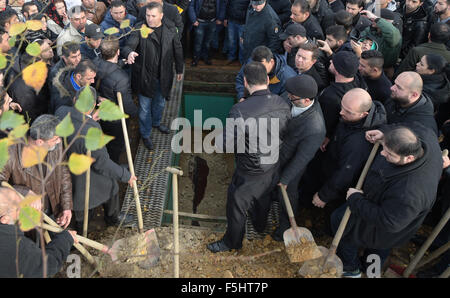 Berlin, Deutschland. 5. November 2015. Trauernden stehen rund um das offene Grab in der muslimischen Abschnitt des Friedhofs bei der Beerdigung des ermordeten Flüchtlingen junge Mohamed in Gatow in Berlin, Deutschland, 5. November 2015. Foto: RAINER JENSEN/Dpa/Alamy Live-Nachrichten Stockfoto