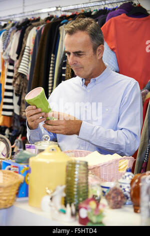 Männlichen Shopper im Secondhand-Laden schauen Ornamente Stockfoto