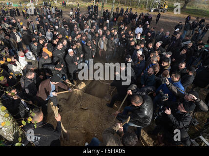 Berlin, Deutschland. 5. November 2015. Trauernden Schaufel Dreck über dem Grab in der muslimischen Abschnitt des Friedhofs bei der Beerdigung des ermordeten Flüchtlingen junge Mohamed in Gatow in Berlin, Deutschland, 5. November 2015. Foto: RAINER JENSEN/Dpa/Alamy Live-Nachrichten Stockfoto