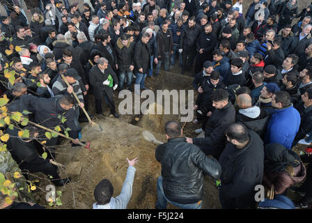 Berlin, Deutschland. 5. November 2015. Trauernden Schaufel Dreck über dem Grab bei der Beerdigung des ermordeten Flüchtlingen junge Mohamed in der muslimischen Abschnitt des Friedhofs in Gatow in Berlin, Deutschland, 5. November 2015. Foto: RAINER JENSEN/Dpa/Alamy Live-Nachrichten Stockfoto