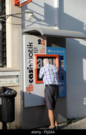 Ein Mann mit dem Cashmatik türkischen Bankasi Geldautomaten in Kyrenia Girne in der türkischen nördlichen Zypern KATHY DEWITT Stockfoto