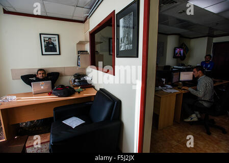 AJ Rais, Leiter des Kabul Pressistan Medienunternehmen, sitzt in seinem Büro unter dem Porträt des Sardar Ahmad, afghanischer Journalist und Gründer von Kabul Pressistan, getötet in terroristischen Anschlag auf das Serena Hotel in Kabul am 20. März 2014, Kabul, Afghanistan Stockfoto