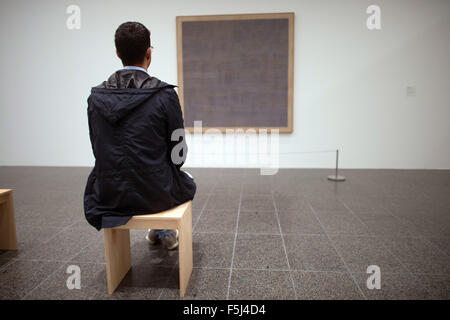 Düsseldorf, Deutschland. 5. November 2015. Ein Besucher schaut das Bild "Falling Blue" aus dem Jahr 1963 von Agnes Martin in der Kunstsammlung Nordrhein-Westfalen in Düsseldorf, Deutschland, 5. November 2015. Die Retrospektive "Agnes Martin" - mit 130 Gemälde, Zeichnungen und Drucke - ersichtlich in der Kunstsammlung Nordrhein-Westfalen vom 7. November 2015 bis 6. März 2016. Foto: FEDERICO GAMBARINI/Dpa/Alamy Live News Stockfoto
