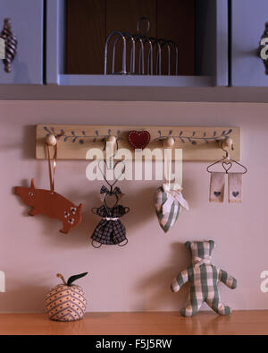 Nahaufnahme der Shaker Stil Dekorationen auf hölzerner Pflock Schiene an einer Küchenwand Stockfoto