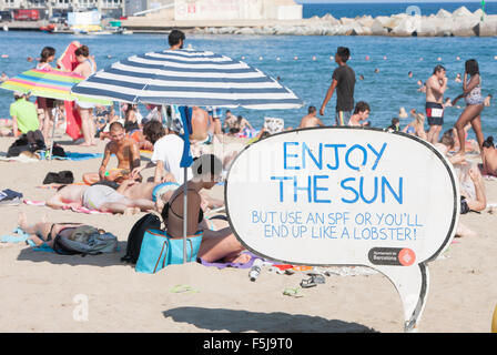 Warnung vor Sonnenbrand, mit Sonnencreme, UV, Gefahren, nicht schlafen am Strand von Barceloneta Strand, Stadtstrand Barcelona, Katalonien, Spanien. Stockfoto