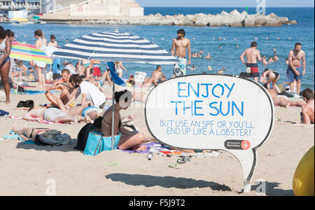 Warnung vor Sonnenbrand, mit Sonnencreme, UV, Gefahren, nicht schlafen am Strand von Barceloneta Strand, Stadtstrand Barcelona, Katalonien, Spanien. Stockfoto