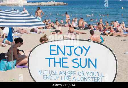 Warnung vor Sonnenbrand, mit Sonnencreme, UV, Gefahren, nicht schlafen am Strand von Barceloneta Strand, Stadtstrand Barcelona, Katalonien, Spanien. Stockfoto