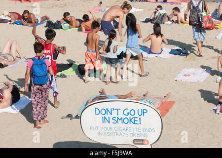 Warnung vor Sonnenbrand, mit Sonnencreme, UV, Gefahren, nicht schlafen am Strand von Barceloneta Strand, Stadtstrand Barcelona, Katalonien, Spanien. Stockfoto