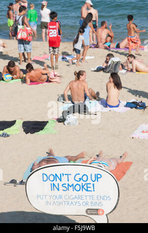 Warnung vor Sonnenbrand, mit Sonnencreme, UV, Gefahren, nicht schlafen am Strand von Barceloneta Strand, Stadtstrand Barcelona, Katalonien, Spanien. Stockfoto