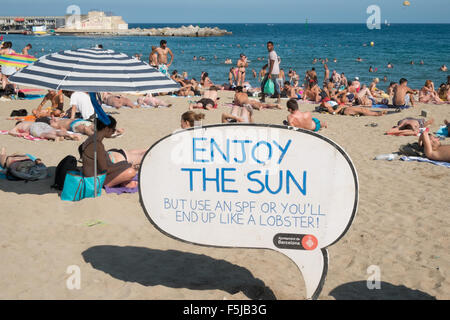 Warnung vor Sonnenbrand, mit Sonnencreme, UV, Gefahren, nicht schlafen am Strand von Barceloneta Strand, Stadtstrand Barcelona, Katalonien, Spanien. Stockfoto