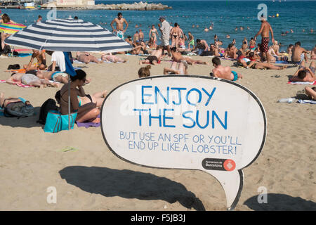 Warnung vor Sonnenbrand, mit Sonnencreme, UV, Gefahren, nicht schlafen am Strand von Barceloneta Strand, Stadtstrand Barcelona, Katalonien, Spanien. Stockfoto