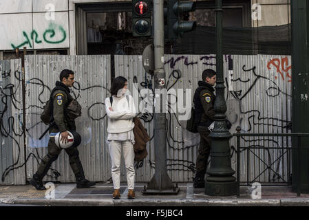 Athen, Griechenland. 5. November 2015. Riot Polizisten vorbeigehen ein Fußgänger warten auf die Straße zu überqueren. Studenten "Gewerkschaften inszenierte eine Demonstration zu protestieren, wie sie behaupten, die Verschlechterung des öffentlichen Bildungswesens aufgrund von Sparmaßnahmen. Bildnachweis: Nikolas Georgiou/ZUMA Draht/Alamy Live-Nachrichten Stockfoto